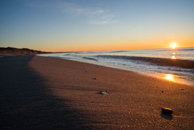 Scenic view of beach against sky during sunset