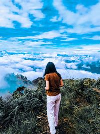 Rear view of woman standing against sky