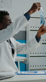 Midsection of man with arms outstretched standing on floor