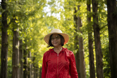 Portrait of woman standing against plants in forest