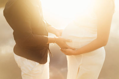 Midsection of couple holding hands