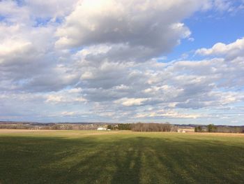 Scenic view of grassy field against cloudy sky