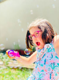 Portrait of young woman standing against blurred background