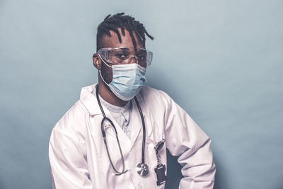 Close-up portrait of doctor against colored background