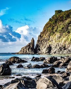 Rocks on beach against sky