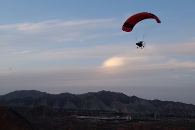 Low angle view of person paragliding against sky