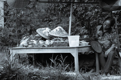 High angle view of woman sitting on table in yard