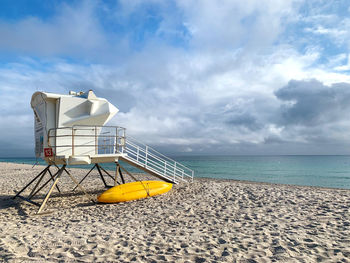 Lifeguard hut on beach against sky