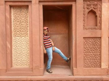 Portrait of boy standing at doorway of historic building