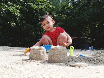 Cute girl playing on sand at beach