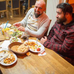 Midsection of man and woman sitting on table