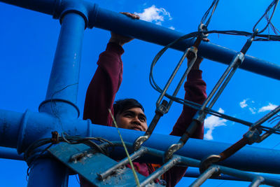 Low angle view of boy on slide in playground