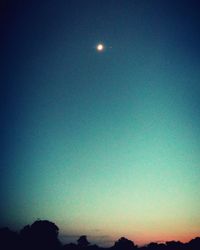 Low angle view of moon against blue sky