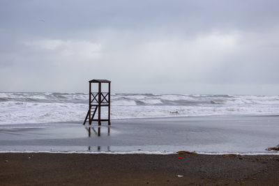 Lifeguard hut on beach against sky