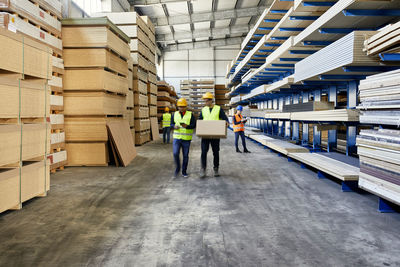 Workers moving and carrying boxes in factory warehouse