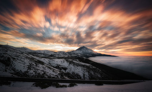 Scenic view of snowcapped mountains against sky during sunset