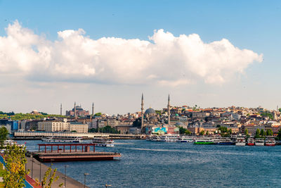 Scenic view of river by buildings against sky