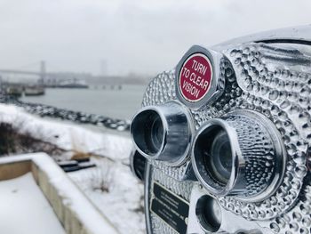 Close-up of coin-operated binoculars against cityscape