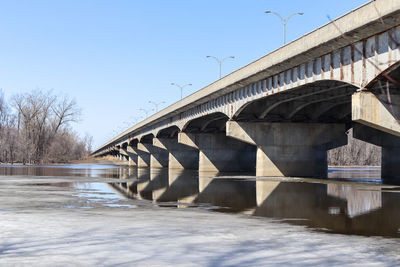 Bridge over river against sky during winter