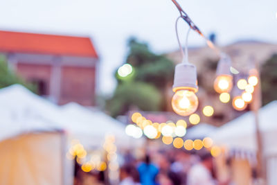 Close-up of illuminated lights hanging on building in city