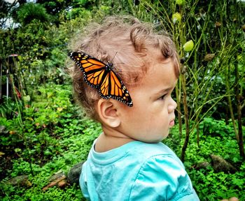 Close-up of cute baby girl with butterfly on head