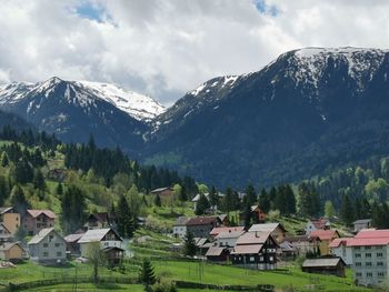 Houses on snowcapped mountain against sky