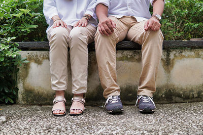 Low section of couple sitting on bench