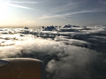 Airplane flying over cloudscape against sky