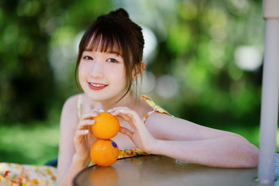 Portrait of young woman sitting at park