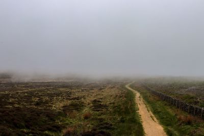 Scenic view of landscape against sky during foggy weather