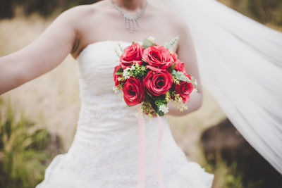 Midsection of woman holding rose bouquet