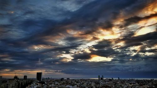 View of cityscape against cloudy sky