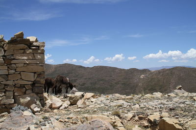 Stack of rocks on mountain against sky