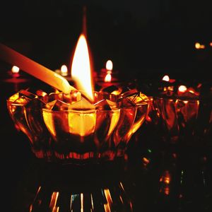 Close-up of lit candle in dark room