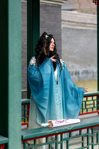 Portrait of young woman standing in city
