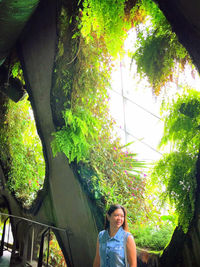 Portrait of young woman against plants