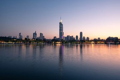 Reflection of buildings in city at waterfront