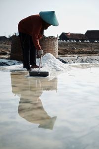 Woman with umbrella standing on shore