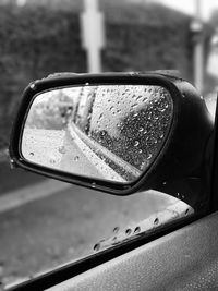 Close-up of wet car side-view mirror