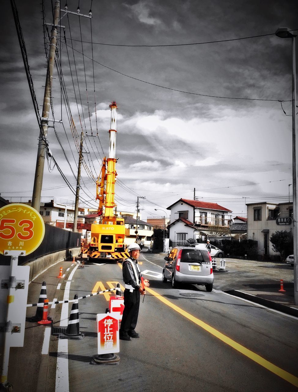 transportation, sky, street, car, mode of transport, building exterior, architecture, land vehicle, cloud - sky, city, road, built structure, human representation, travel, city life, city street, incidental people, cloudy, on the move