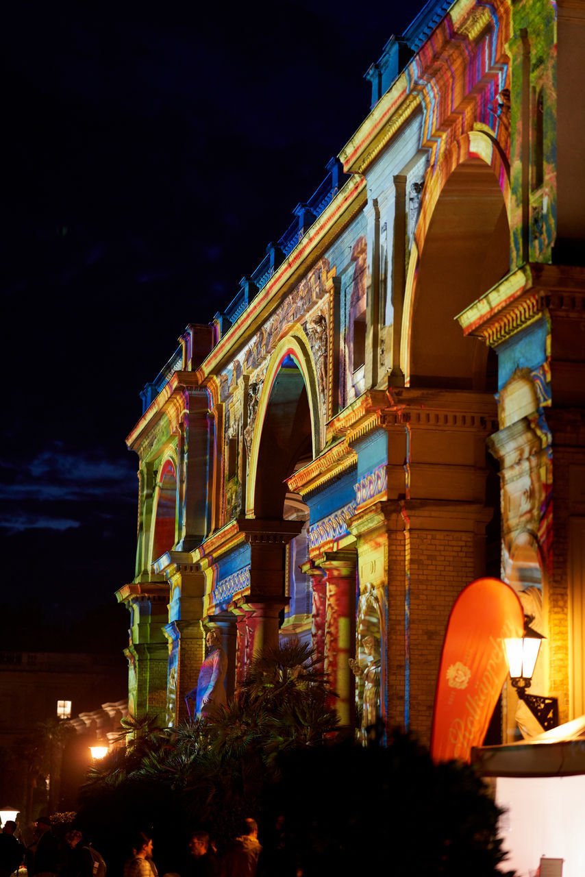 LOW ANGLE VIEW OF ILLUMINATED BUILDINGS AT NIGHT