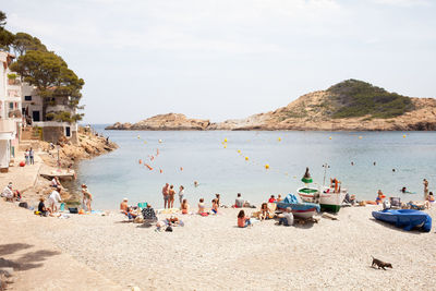 People at beach against sky