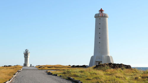 Low angle view of lighthouse amidst buildings against sky