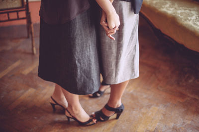 Low section of people standing on wooden floor