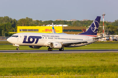 Side view of airplane on airport runway against sky