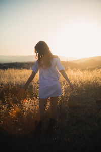 Beautiful model girl poses in nature in a yellow field