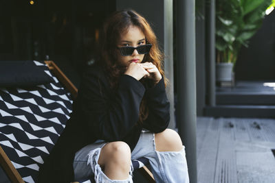 Young woman sitting in sunglasses