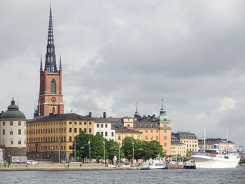 View of buildings in city against cloudy sky