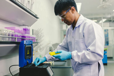 Healthcare doctor taking sample from test tube using micropipette. 