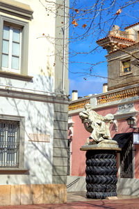 Low angle view of statue against building in city